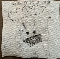 a piece of paper with a drawing of a boy wearing a hat